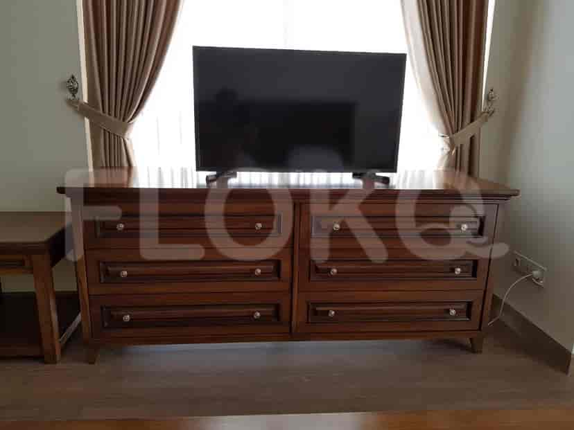 Living room with a dresser, smart TV, and dark curtains.