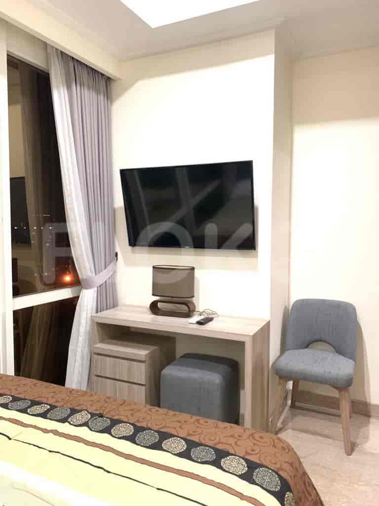 A bedroom featuring a TV, desk, and chair.