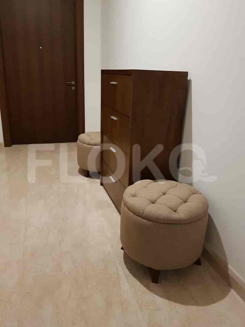 Hallway with a shoe rack and two ottomans.