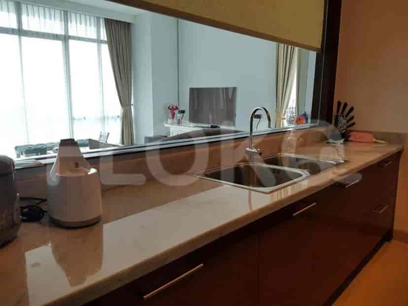 Modern kitchen with marble countertops and dark wood cabinetry.