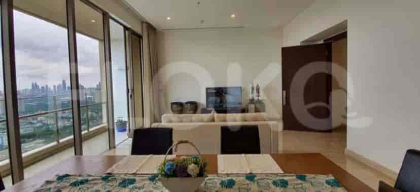 A modern living and dining area with large windows and a city view.