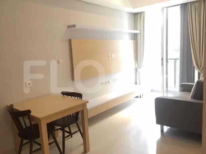 Living room featuring a dining table, a TV unit, and a sofa with balcony access.