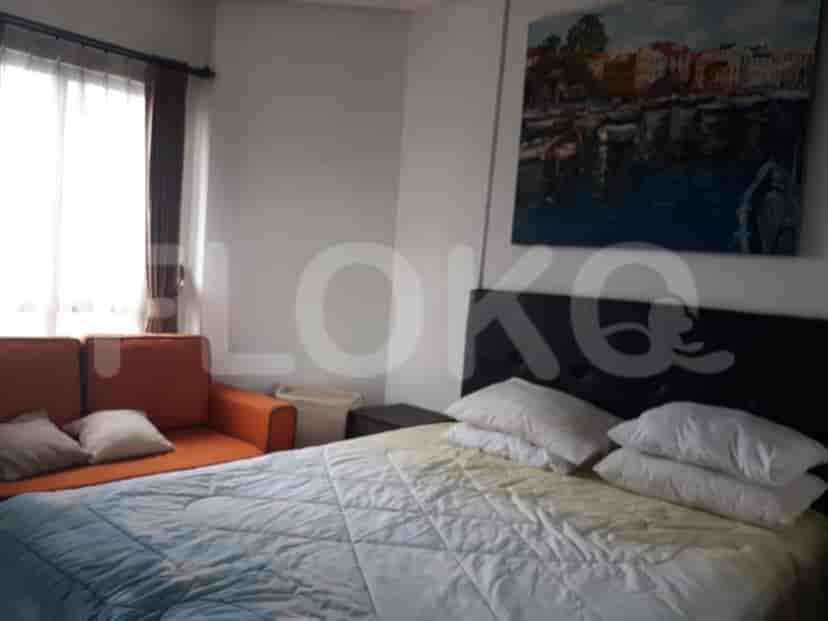 Bedroom with a bed, a sofa, and artwork.