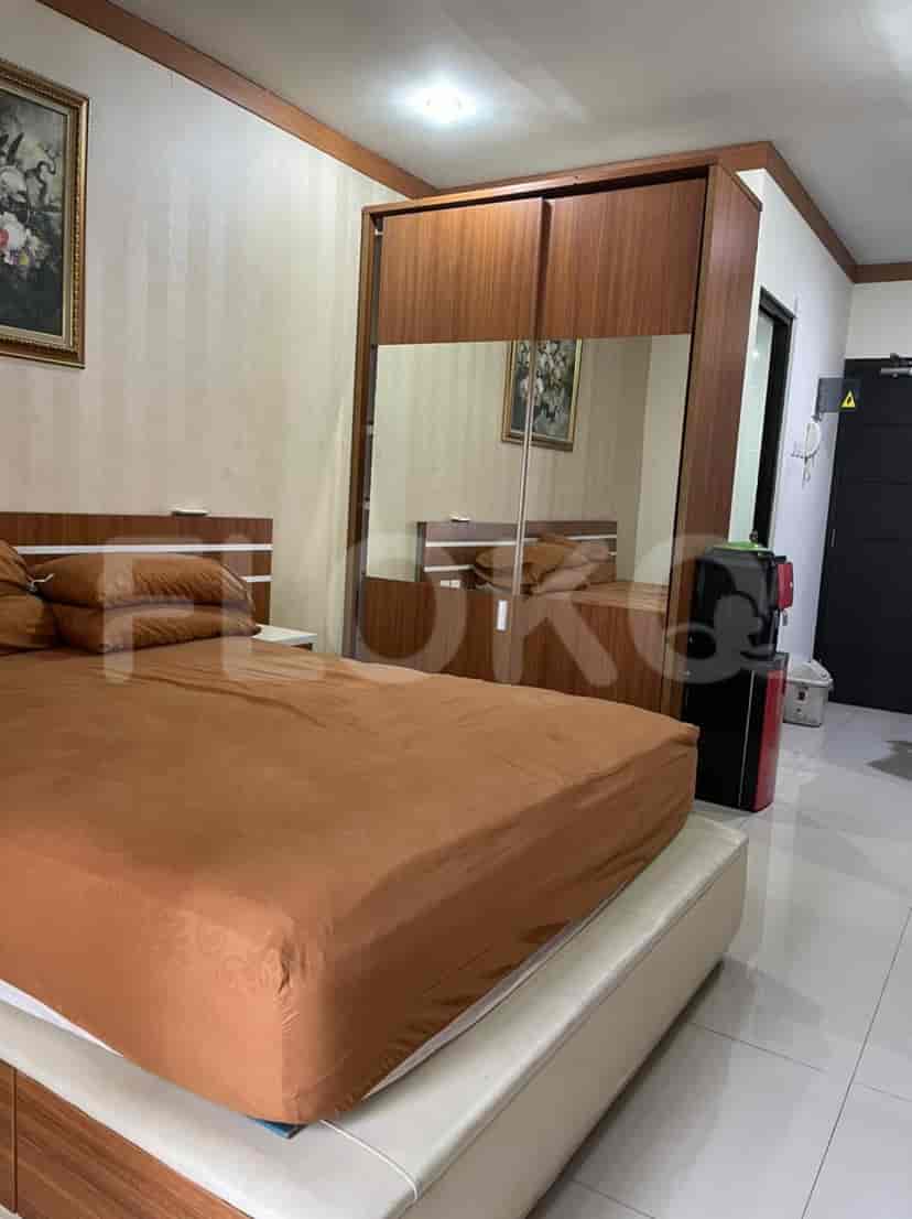 A modern bedroom with a large bed, a mirrored closet, and a simple artwork.
