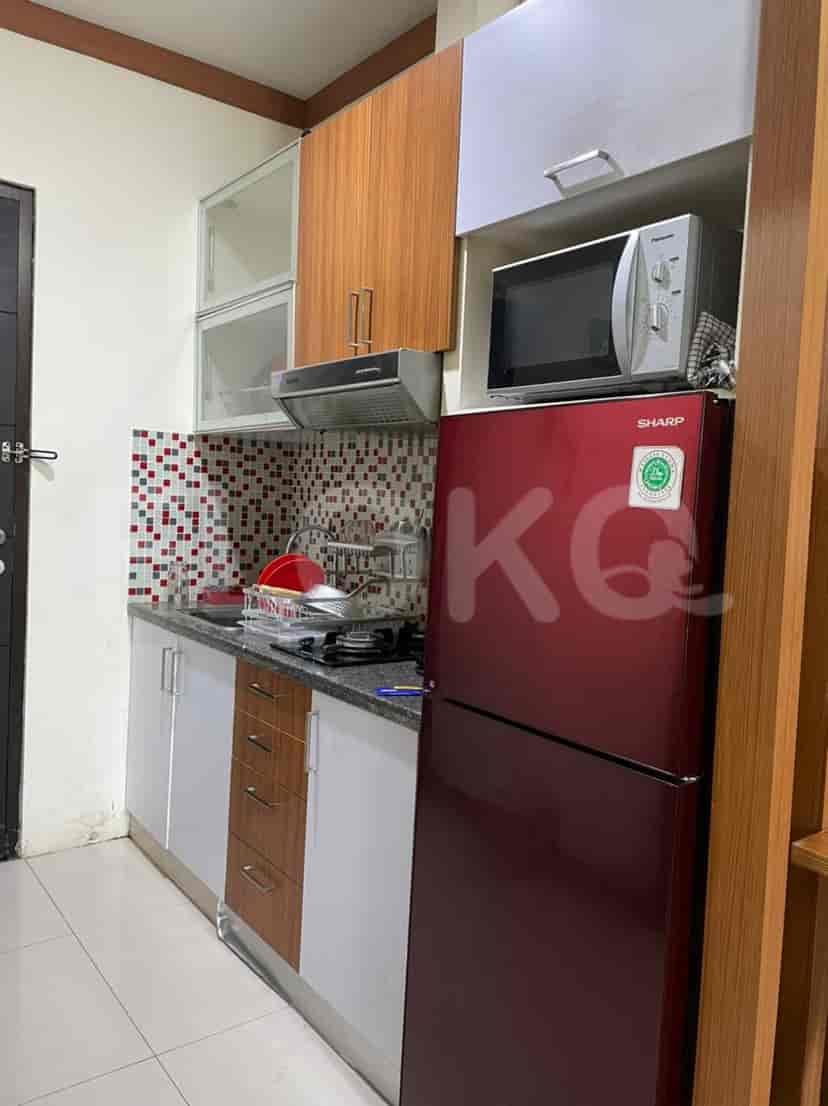 A small but functional kitchen with cabinets, a refrigerator, and a microwave.