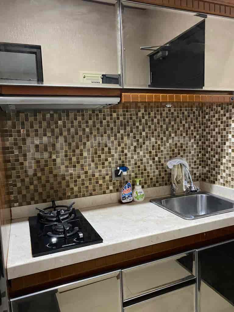 A small kitchen with cabinets, stove, and sink.