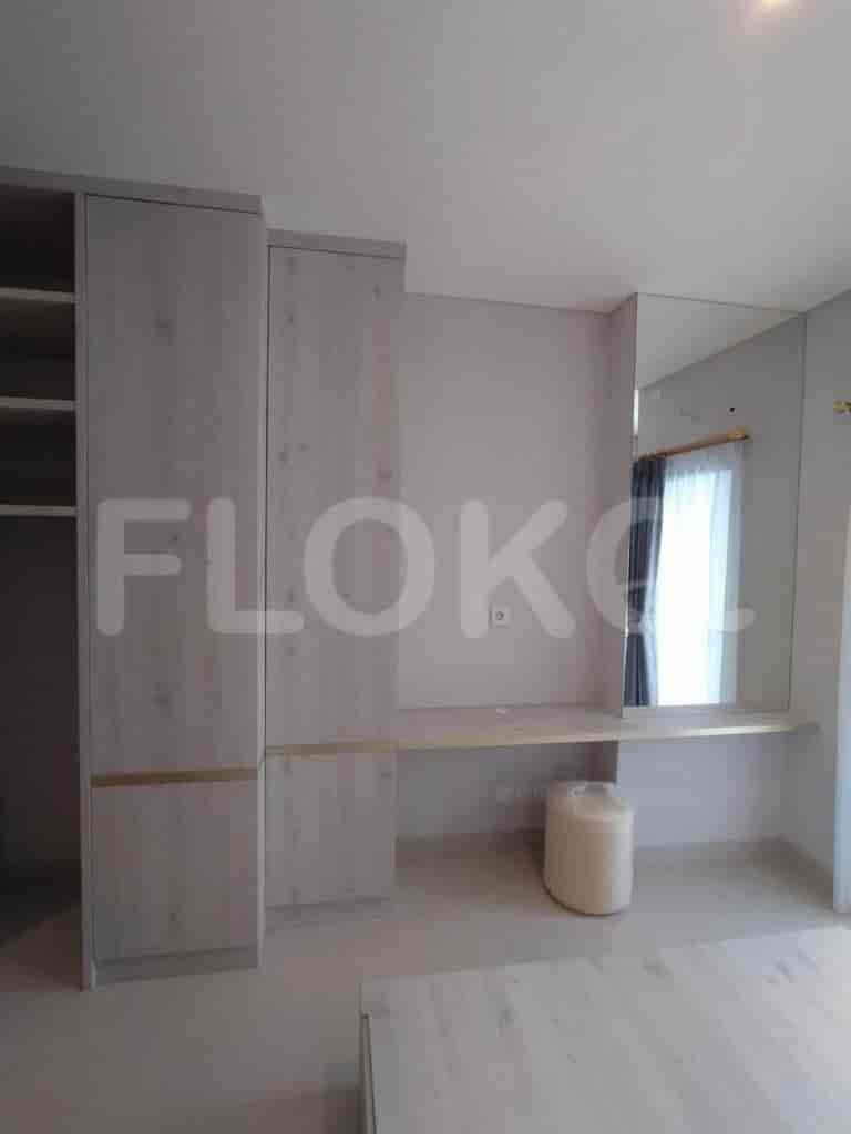 Bedroom with a wooden desk, built-in cabinets, and a large mirror.