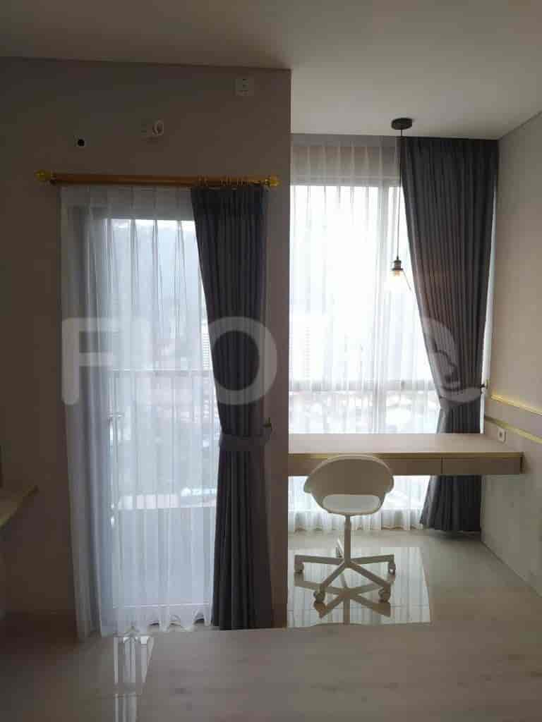 Bedroom with a desk, curtains, and a chair.
