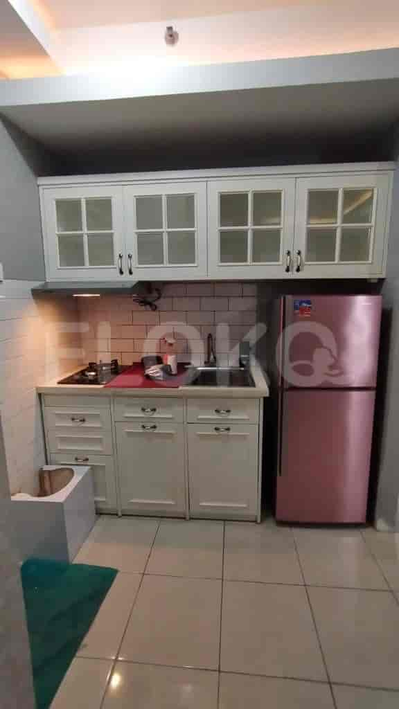 A kitchen with a stove, a refrigerator, and cabinets.
