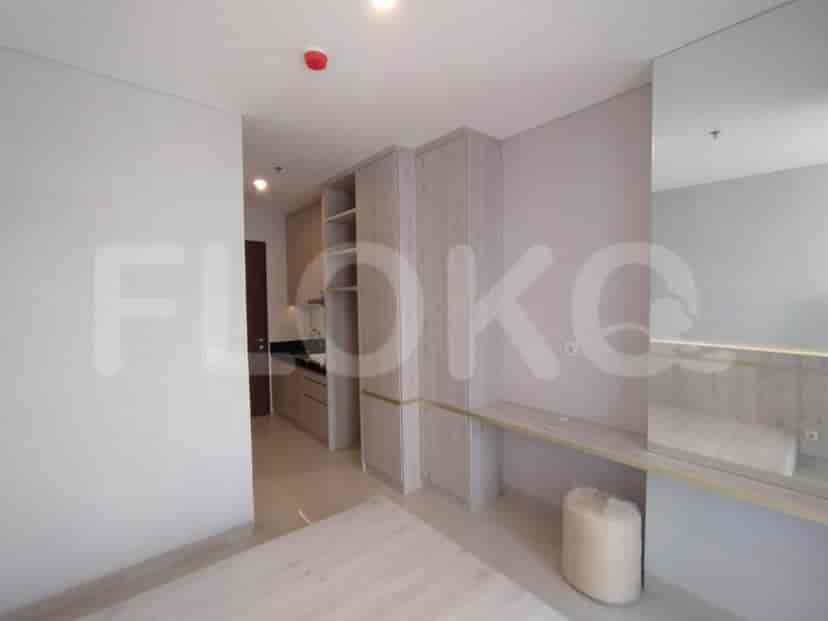 Bedroom connected to a small kitchen area and a mirrored desk.