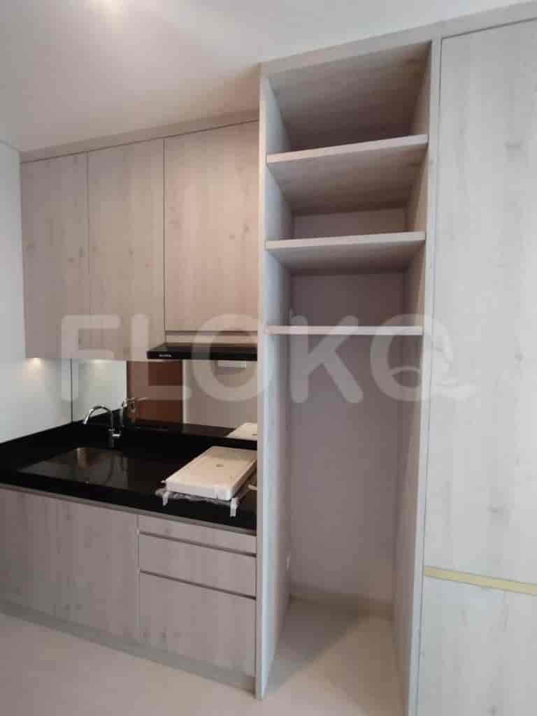 Modern kitchen with wooden cabinets and black countertops.