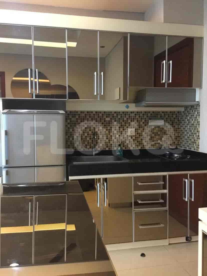 A modern kitchen with stainless steel appliances and mirror-finished cabinets.