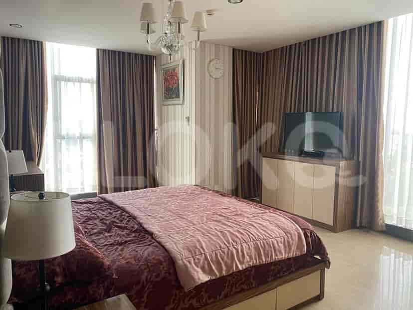 Master bedroom featuring a large bed, TV, and elegant curtains.