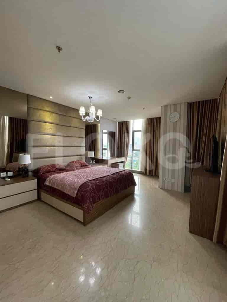 Spacious master bedroom with a king-sized bed, elegant decor, and large windows.