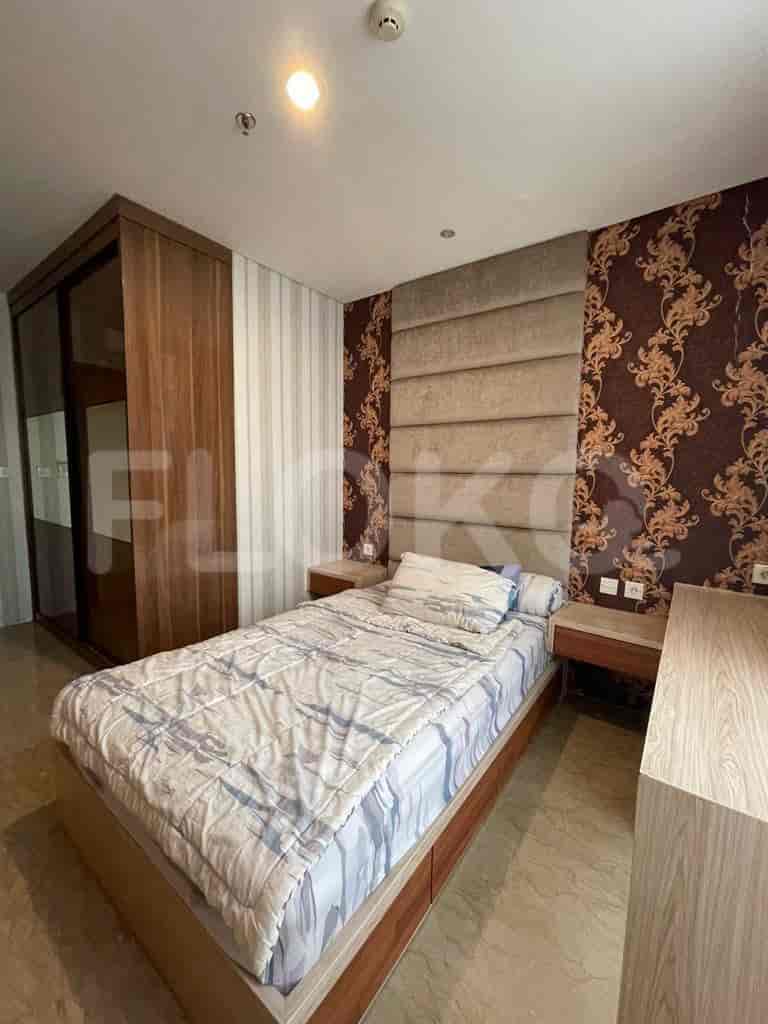 Contemporary bedroom with a single bed, wooden closet, and patterned wallpaper.