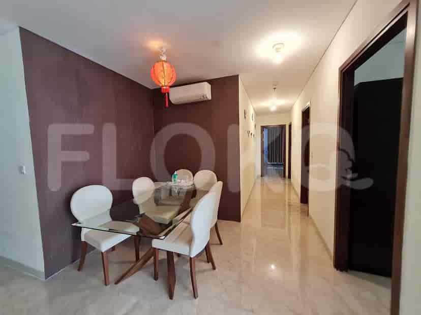 A dining area featuring a glass table with white chairs, a hallway with doors, and a decorative red lantern.