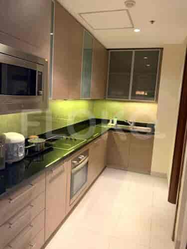 Dapur modern dengan lemari kayu, meja hitam, dan peralatan built-in.