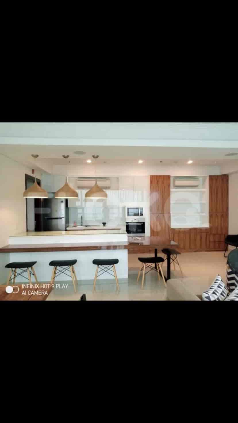 Modern open-concept kitchen and dining area with wooden accents and pendant lights.
