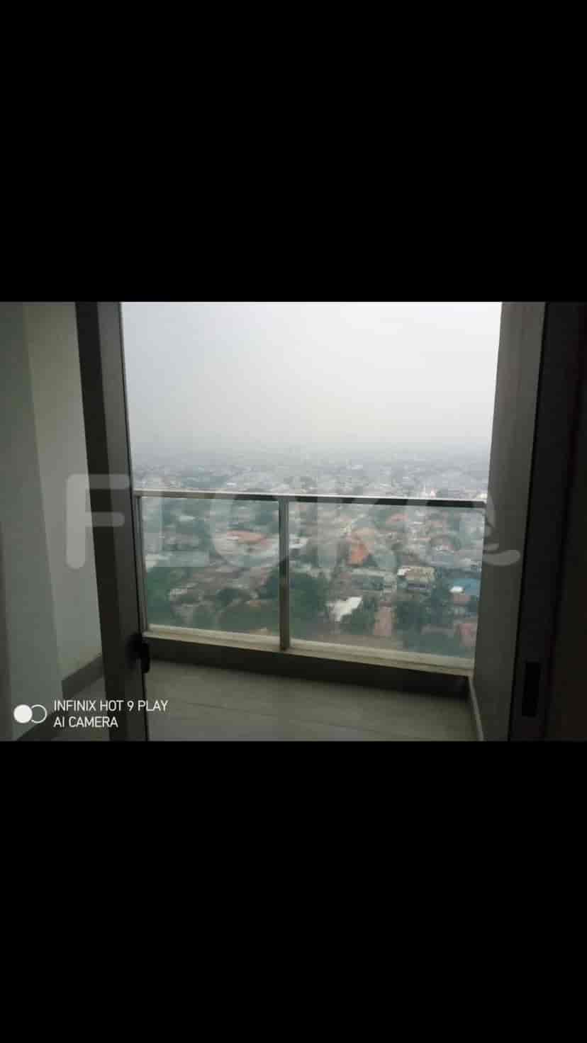 Balcony overlooking a cityscape with a glass railing.