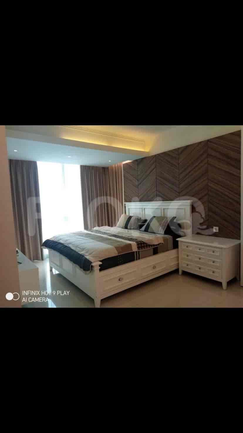 Elegant bedroom with a large bed and wooden accent wall.