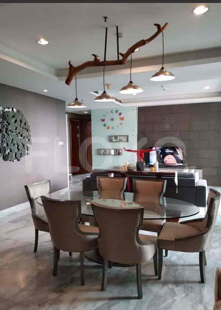 Dining room with a round table, chairs, and a TV.