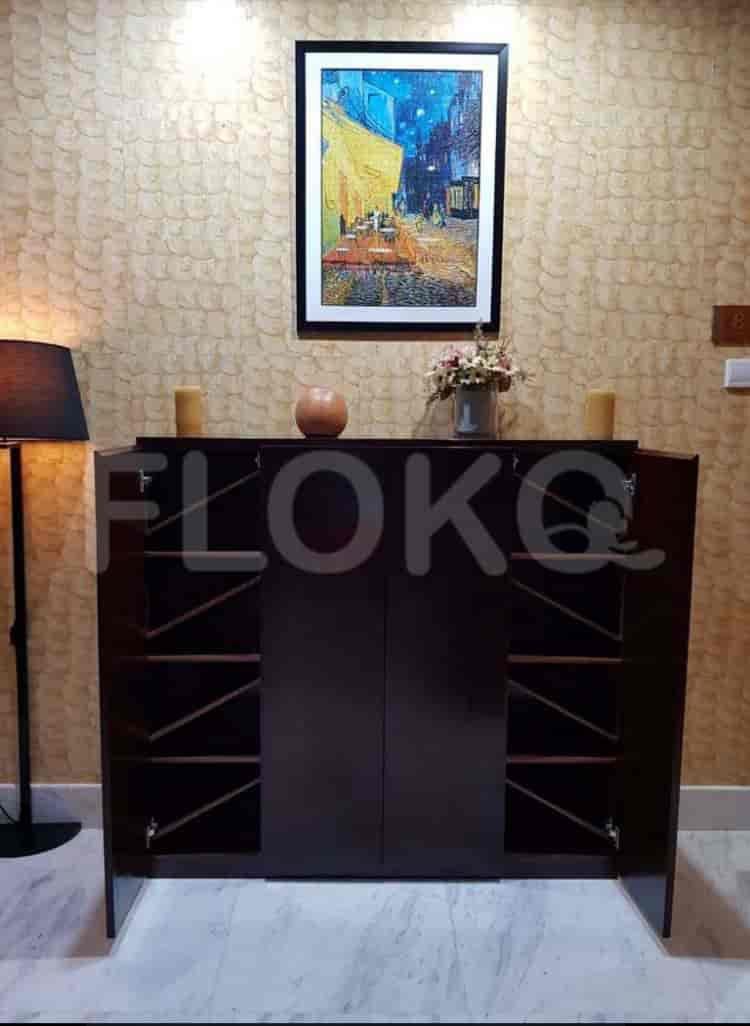 Hallway with a painting and a shoe cabinet.