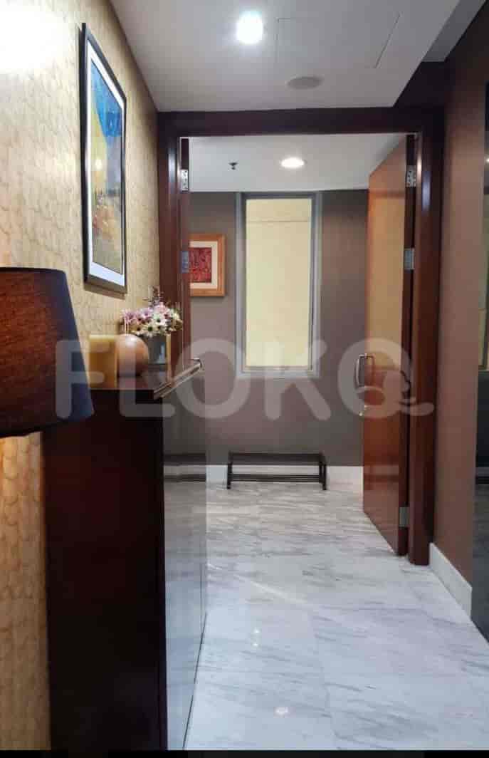 Hallway with decor, artwork, and a door.