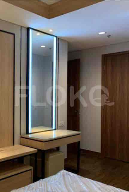 Bedroom featuring a dressing table with a large mirror, a bed, and wooden accents.