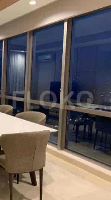 Dining area with a white rectangular table, upholstered chairs, and a panoramic city view.