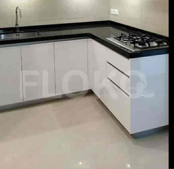 A modern kitchen with white cabinets and black countertops.