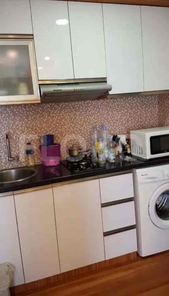 Compact kitchen with white cabinets, a gas stove, and a washing machine.