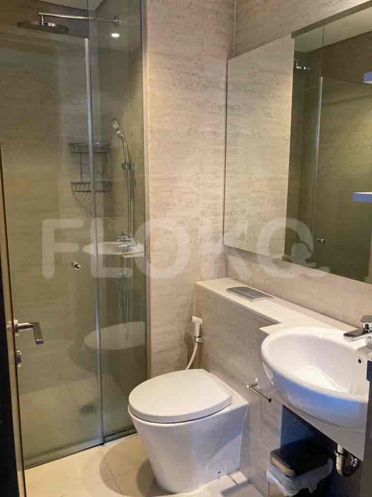 Modern bathroom with a walk-in shower, toilet, and sink.