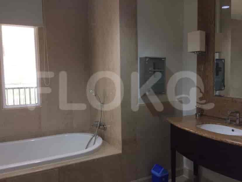 A well-lit bathroom with a bathtub, sink, and mirror.