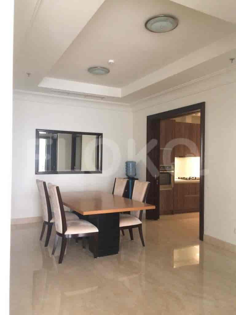 A bright dining room with a table, chairs, and access to the kitchen.