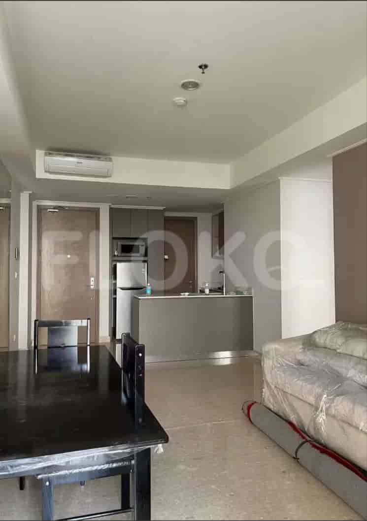 A combined living and kitchen area, featuring a table, kitchen and bed.