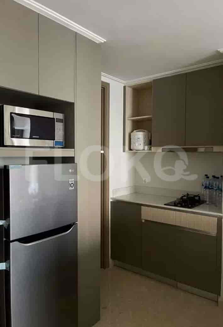 A modern kitchen with cabinets, microwave, and refrigerator.