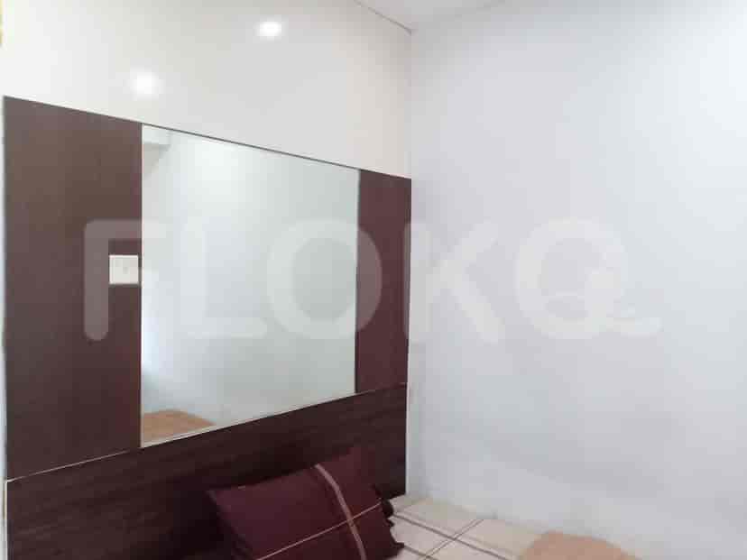 A bedroom with a bed and a wall mirror.