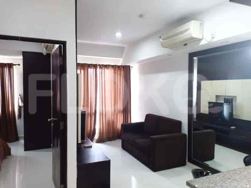 A living room with a sofa, curtains, and an air conditioner.