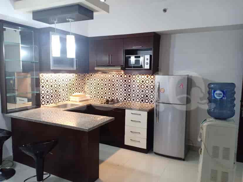 A modern kitchen with dark wood cabinetry, a breakfast bar, and stainless steel appliances.