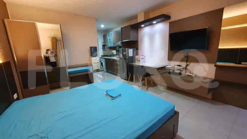 Another view of the bedroom, showing the bed and part of the kitchen area.