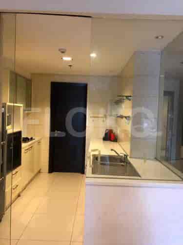 Modern kitchen with stainless steel sink, sleek cabinets, and a black door.