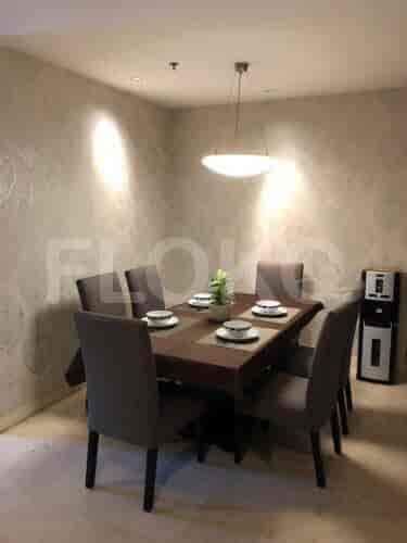 Dining table with six chairs and a hanging light.