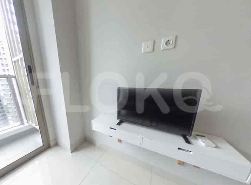A small TV mounted on a white floating shelf with a window to the side.