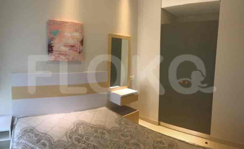 A bedroom featuring a bed, artwork, vanity area, and a closet.