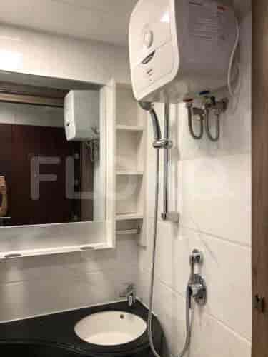 A modern bathroom with a compact design, featuring a floating vanity and a glass-enclosed shower.