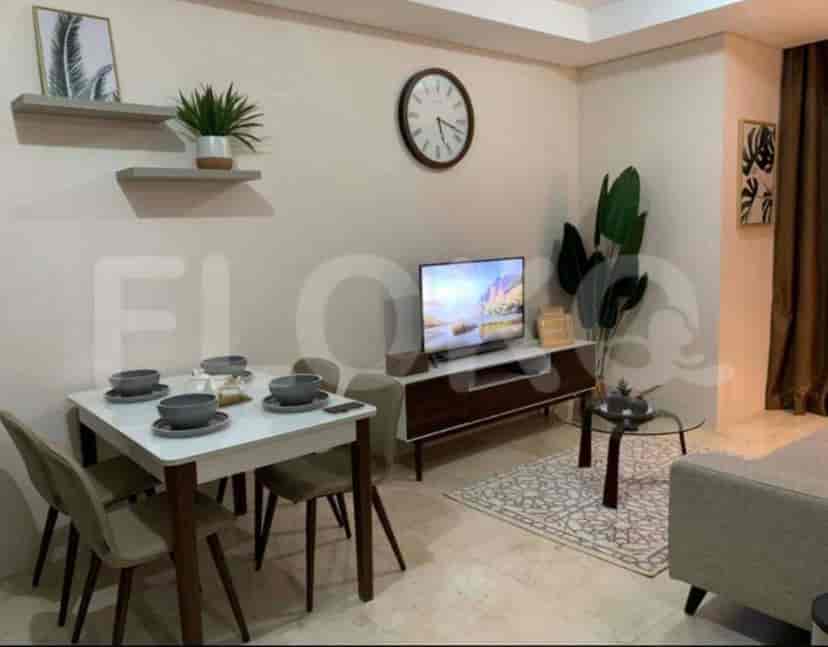A dining area and living space with a white dining table, chairs, TV, and decorative plants.