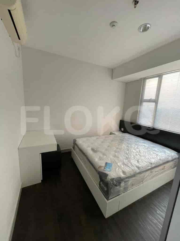 Bedroom with bed, desk, and window.