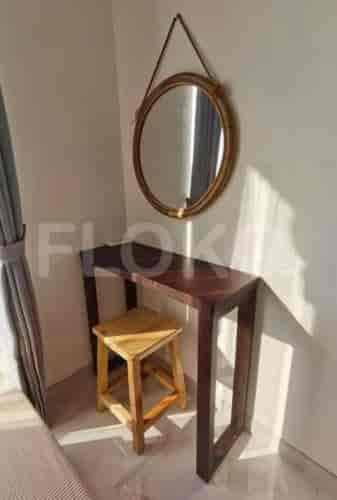 A small vanity area with a mirror and stool.