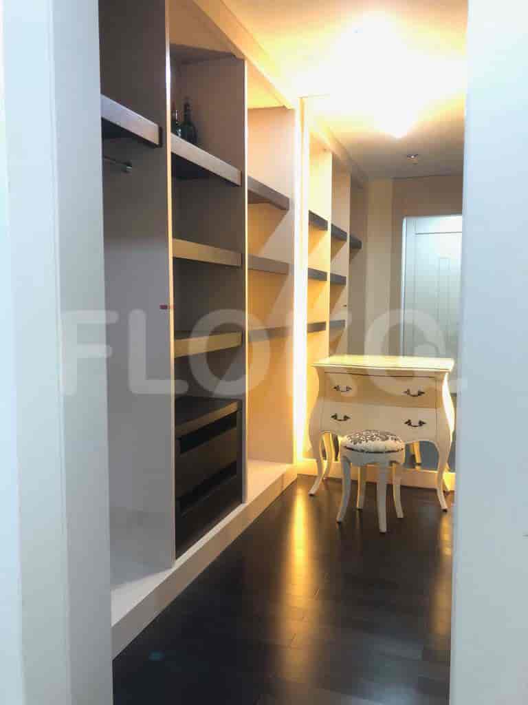 A spacious walk-in closet with multiple shelves and a dressing table.