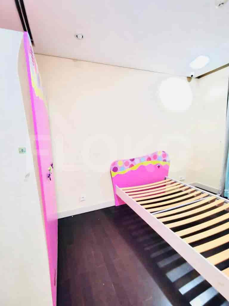 A kids bedroom featuring a pink bed and wardrobe.